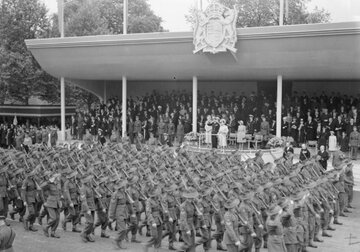 Londyńska Parada Zwycięstwa. Maszerują Australijczycy, na&nbsp;drugim planie kr&oacute;l Jerzy VI i&nbsp;kr&oacute;lowa Elżbieta