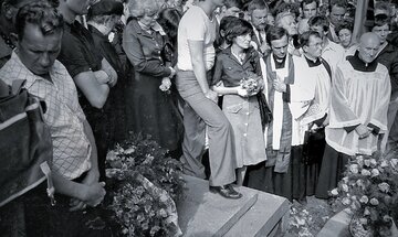 Pogrzeb Grzegorza Przemyka. Jego matka, poetka i&nbsp;działaczka opozycyjna Barbara Sadowska, stoi w&nbsp;środku z&nbsp;wiązanką kwiat&oacute;w, obok niej ks. Jerzy Popiełuszko, po&nbsp;prawej: ks. Stefan Niedzielak. Cmentarz Powązkowski w&nbsp;Warszawie, 19 maja 1983&nbsp;r.