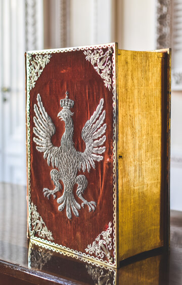 Pudło w ozdobnej oprawie ze zbiorów arcybiskupa warszawskiego i prymasa Królestwa Polskiego Jana Pawła Woronicza, w którym prawdopodobnie była przechowywana Konstytucja 3 Maja, ukrywana przed Rosjanami po rozbiorach państwa polskiego. Oprawa przedstawia 