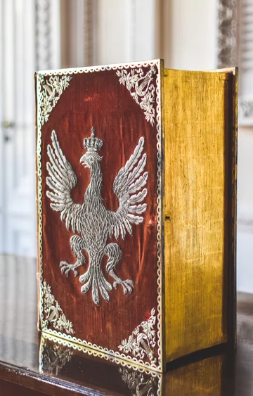 Pudło w ozdobnej oprawie ze zbiorów arcybiskupa warszawskiego i prymasa Królestwa Polskiego Jana Pawła Woronicza, w którym prawdopodobnie była przechowywana Konstytucja 3 Maja, ukrywana przed Rosjanami po rozbiorach państwa polskiego. Oprawa przedstawia 