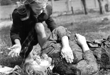 Ofiary bombardowania Luftwaffe w Warszawie, 14 września 12-letnia Kazimiera Mika nad swoją 14-letnią zamordowaną siostrą. Fotograf Julien Bryan opisał precyzyjnie scenę śmierci dziewczynki. Według jego relacji dwa niemieckie samoloty zrzuciły dwie bomby niedaleko małego domku na obrzeżach Warszawy, niedaleko ulicy Jana Ostroroga, zabijając dwie kobiety. Niedaleko znajdowało się pole, na którym siedem kobiet wykopywało ziemniaki. W Warszawie panował już wówczas głód, dlatego zaraz po nalocie kobiety wstały i przystąpiły do pracy. Niemcy nie byli jednak usatysfakcjonowani mordem na cywilach, dlatego wkrótce wrócili i ostrzelali kobiety z broni maszynowej, zabijając kolejne dwie osoby. Pięciu pozostałym kobietom udało się uciec.