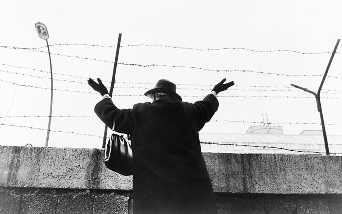 Mur Berliński. Starsza pani machająca do znajomego w sektorze wschodnim (1961)