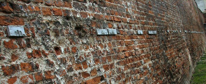 Mur, pod którym Niemcy zamordowali pocztowców z Poczty gdańskiej. Artysta umieścił na nim symboliczne ślady palców tam, gdzie aresztowani pocztowcy trzymali ręce