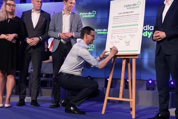 Mateusz Morawiecki (C) podczas spotkania w KPRM z młodymi ludźmi ws. przyjętego przez rząd projektu ustawy dot. zerowego PIT-u dla osób do 26. roku życia 