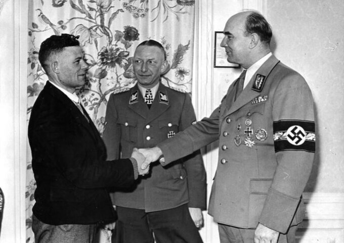 Heinz Reinefarth (w środku) wraz z Arthurem Greiserem wita milionowego Niemca przesiedlonego do Kraju Warty ze wschodniej Europy w ramach niemieckiej akcji przesiedleńczej Heim ins Reich – marzec 1944