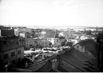 Lublin Lublin, znajdujący się przed wojną w centralnej części Polski, od 1939 r. powiększył się trzykrotnie. W dwudziestoleciu międzywojennym również wyróżniał się wyraźnie na tle regionu. Drugie co do wielkości w w woj. lubelskim Siedlce liczyły w 1931 r. 36,9 tys. mieszkańców. Liczba ludności w 1939 r.: 122 tys., obecnie: 340 tys. Na zdjęciu: widok z Bramy Krakowskiej na dworzec autobusowy, targ i kościół Karmelitów, lipiec 1939 r.