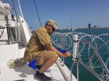 Piotr Szalaty podczas instalowania drutu ostrzowego na&nbsp;jachcie