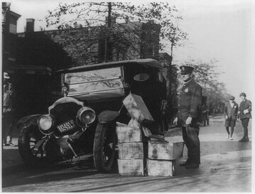 USA. Policjant z&nbsp;wrakiem samochodu i&nbsp;skonfiskowanym bimbrem, 1922