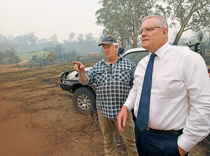 Premier Australii Scott Morrison ogląda skutki pożarów na farmie w stanie Wiktoria