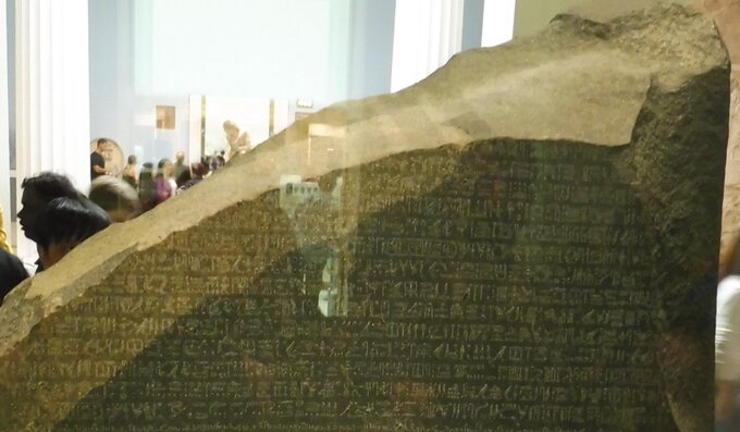 Tekst zapisany hieroglifami na kamieniu z Rosetty. Kamień umieszczony jest za grubą szybą i znajduje się w British Museum nieprzerwanie od 1802 roku
