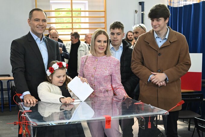 18.05.2025. Karol Nawrocki (L) z żoną Martą Nawrocką (C) głosują w lokalu wyborczym w Gdańsku