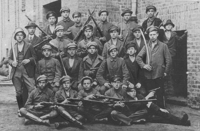 Grupa powstańców uzbrojonych w karabiny i szable oraz pistolety Parabellum P-08