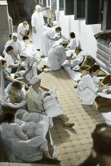 Poród w czasie bombardowania Koloryzowana wersja fotografii Juliena Bryana. Podczas bombardowania noworodki i ich matki zostały przeniesione do piwnicy szpitala. Niektóre kobiety były w trakcie porodu. Odłamki bomb zabiły lub raniły część noworodków.