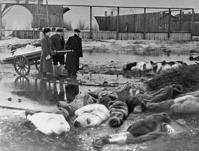 Trzej mężczyźni chowają zmarłych mieszkańców Leningradu, 1942 r.