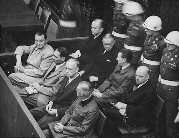 Ława oskarżonych w&nbsp;Norymberdze. Od&nbsp;lewej w&nbsp;pierwszym rzędzie: G&ouml;ring, Hess, Ribbentrop, Keitel, w&nbsp;drugim rzędzie: D&ouml;nitz, Raeder, Schirach, Sauckel