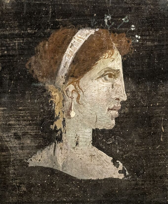 Najprawdopodobniej namalowany pośmiertnie portret Kleopatry z rudymi włosami i wyrazistymi rysami twarzy, ubranej w królewski diadem i wysadzane perłami spinki do włosów, z rzymskiego Herkulanum , Włochy, I wiek n.e.