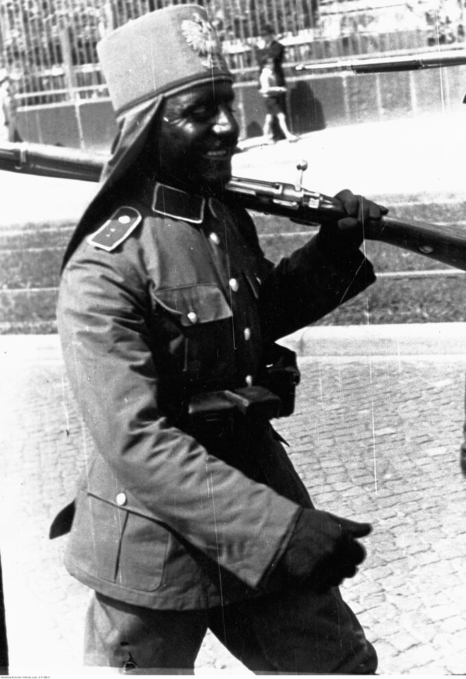 Czarnoskóry żołnierz w pochodzie uzbrojony w karabin 7,9 mm Mauser wz. 1898 i pas z ładownicami. Parada Ligi Morskiej i Kolonialnej w Toruniu, w 1939 r.