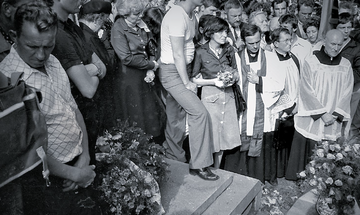 Pogrzeb Grzegorza Przemyka. Jego matka, poetka i&nbsp;działaczka opozycyjna Barbara Sadowska, stoi w&nbsp;środku z&nbsp;wiązanką kwiat&oacute;w, obok niej ks. Jerzy Popiełuszko, po&nbsp;prawej: ks. Stefan Niedzielak. Cmentarz Powązkowski w&nbsp;Warszawie, 19 maja 1983&nbsp;r.