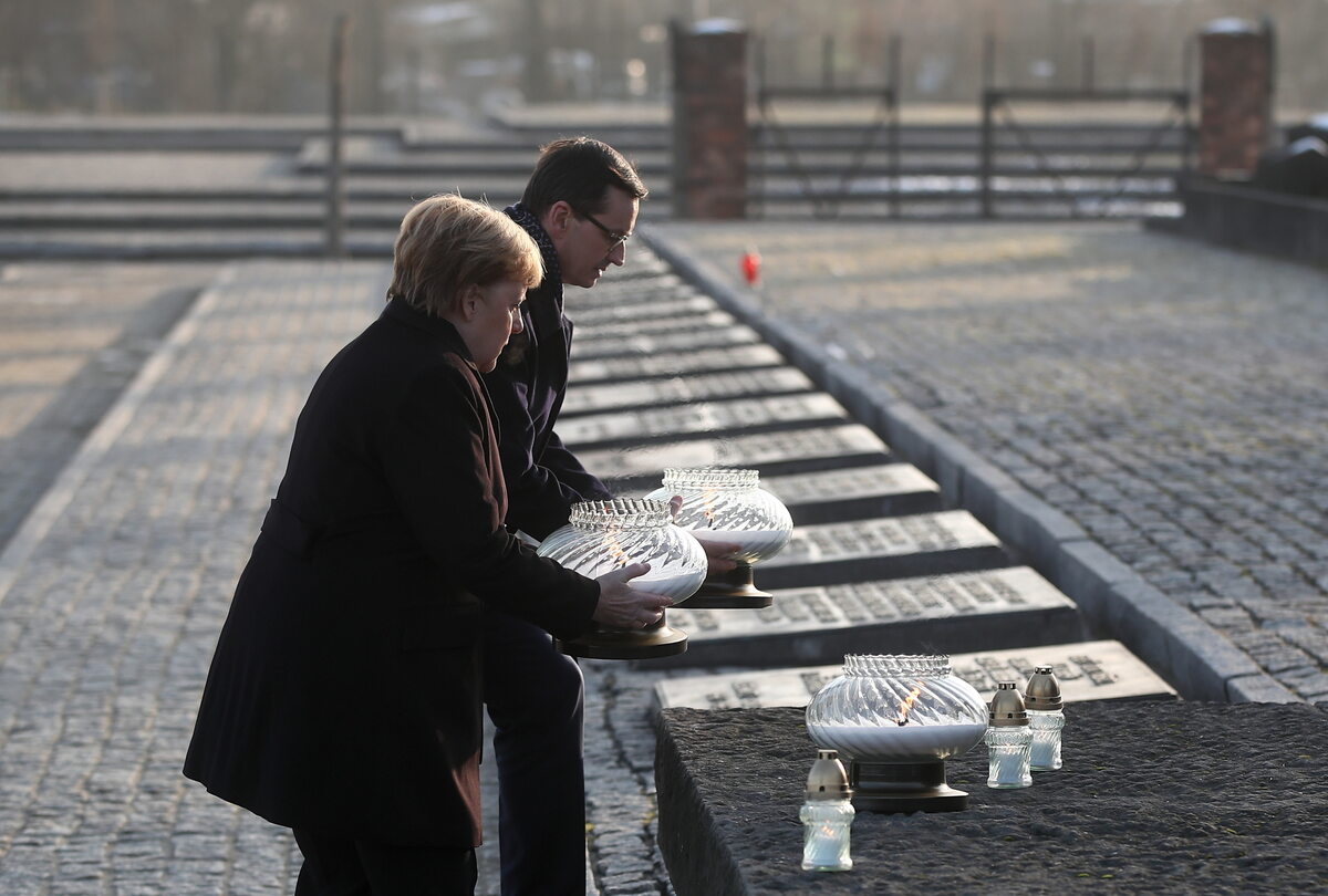 Kanclerz Niemiec Angela Merkel (L) i premier Mateusz Morawiecki (P) zapalają znicze przy Międzynarodowym Pomniku Ofiar Obozu na terenie byłego obozu zagłady Auschwitz. 