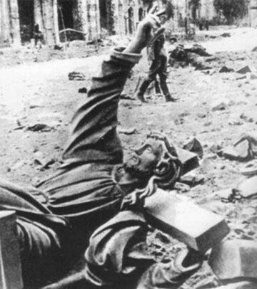 Figura wśr&oacute;d warszawskich gruz&oacute;w, po&nbsp;Powstaniu Warszawskim 1944&nbsp;r. Chrystus, choć leżący, nadal wskazywał ręką niebo