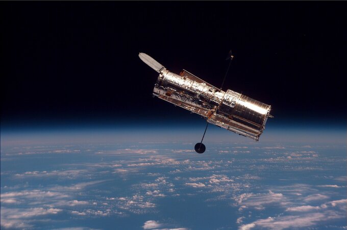 Teleskop Hubble&rsquo;a widziany z&nbsp;pokładu promu kosmicznego Discovery. Zdjęcie wykonano podczas drugiej misji serwisowej STS-82, w&nbsp;1997 roku