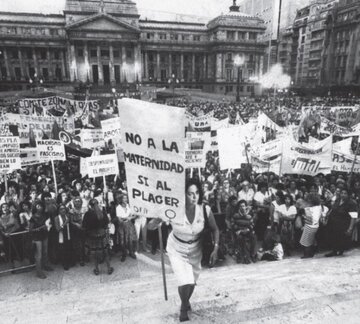 Argentyńska działaczka feministyczna Mar&iacute;a Elena Oddone niesie baner z&nbsp;napisem "Nie dla&nbsp;macierzyńska, tak dla&nbsp;przyjemności" podczas manifestacji, 1984 rok