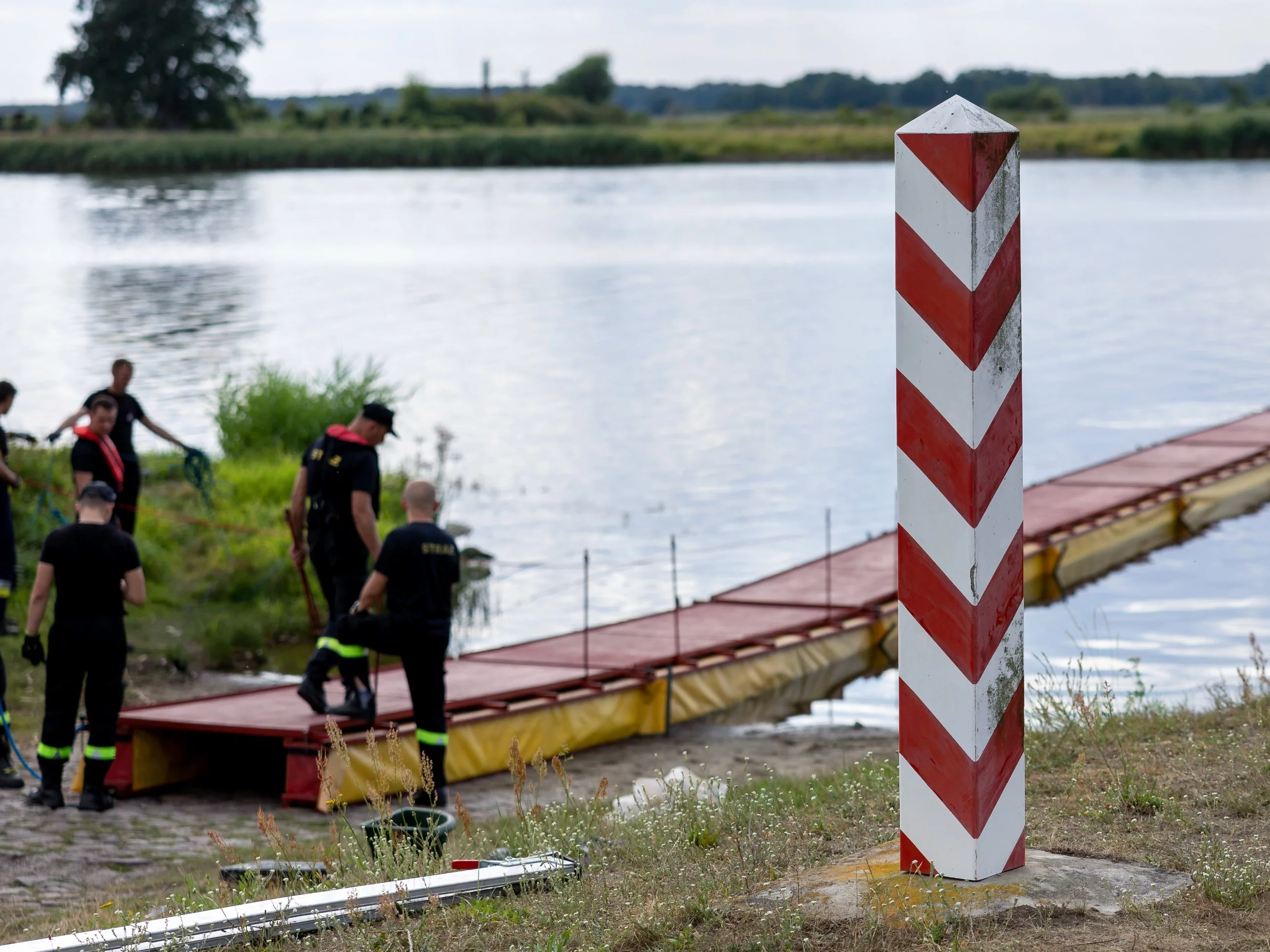 Strażacy ustawiają specjalną zaporę, której zadaniem będzie zatrzymywanie śniętych ryb płynących z nurtem Odry