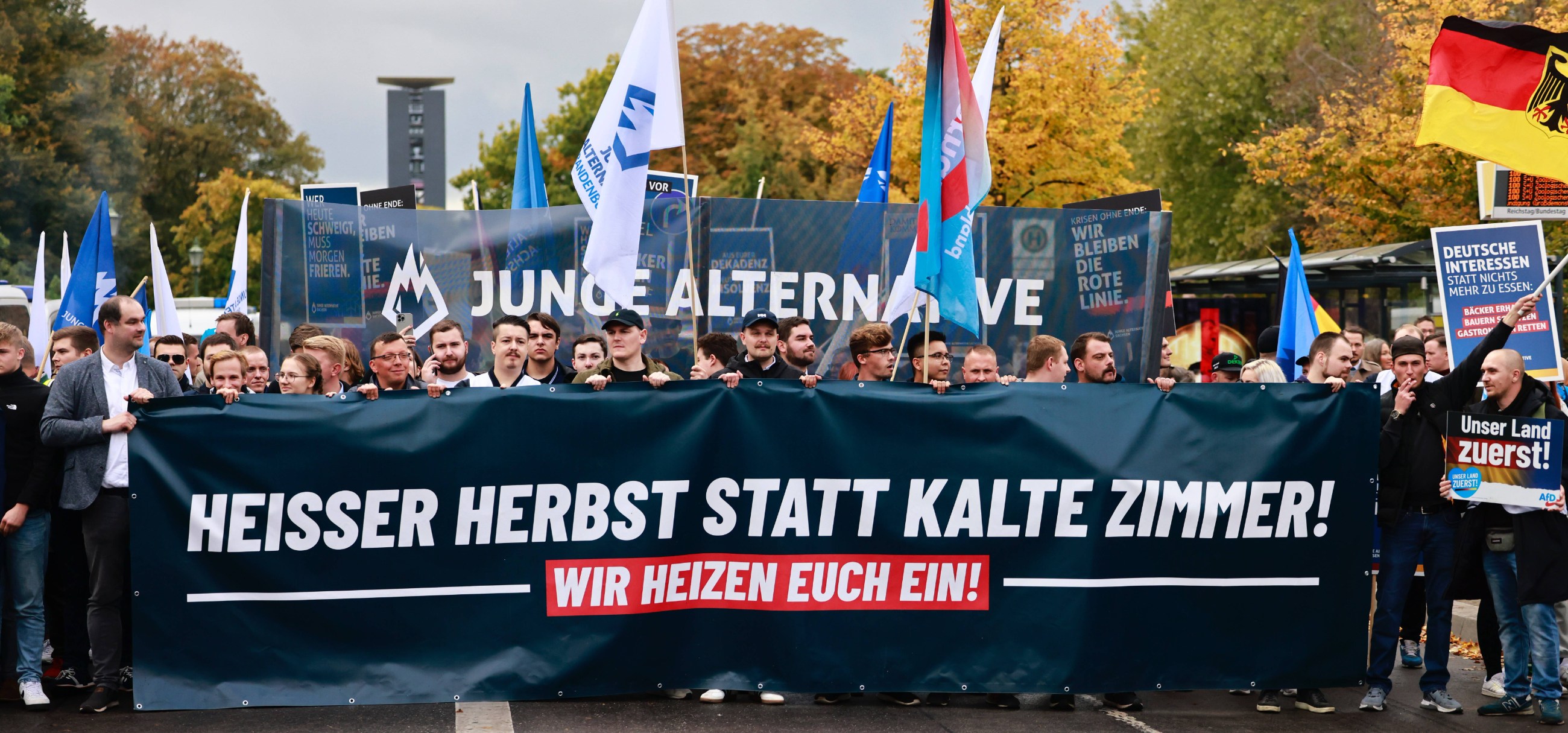 Demonstracja przeciwko inflacji. Protestujący trzymają transparent z napisem "Gorąca jesień zamiast zimnych pomieszczeń! Ogrzejemy cię!" Berlin. Październik 2022 r