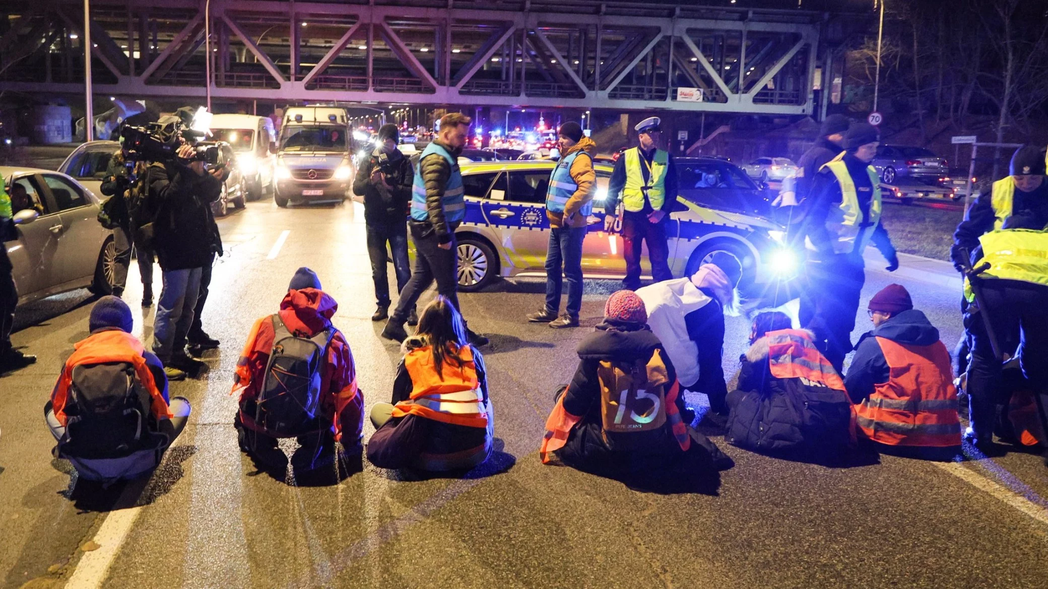 Policja na Wisłostradzie w okolicach Mostu Gdańskiego w Warszawie, i blokujący trasę protestujący "aktywiści" z Ostatniego Pokolenia