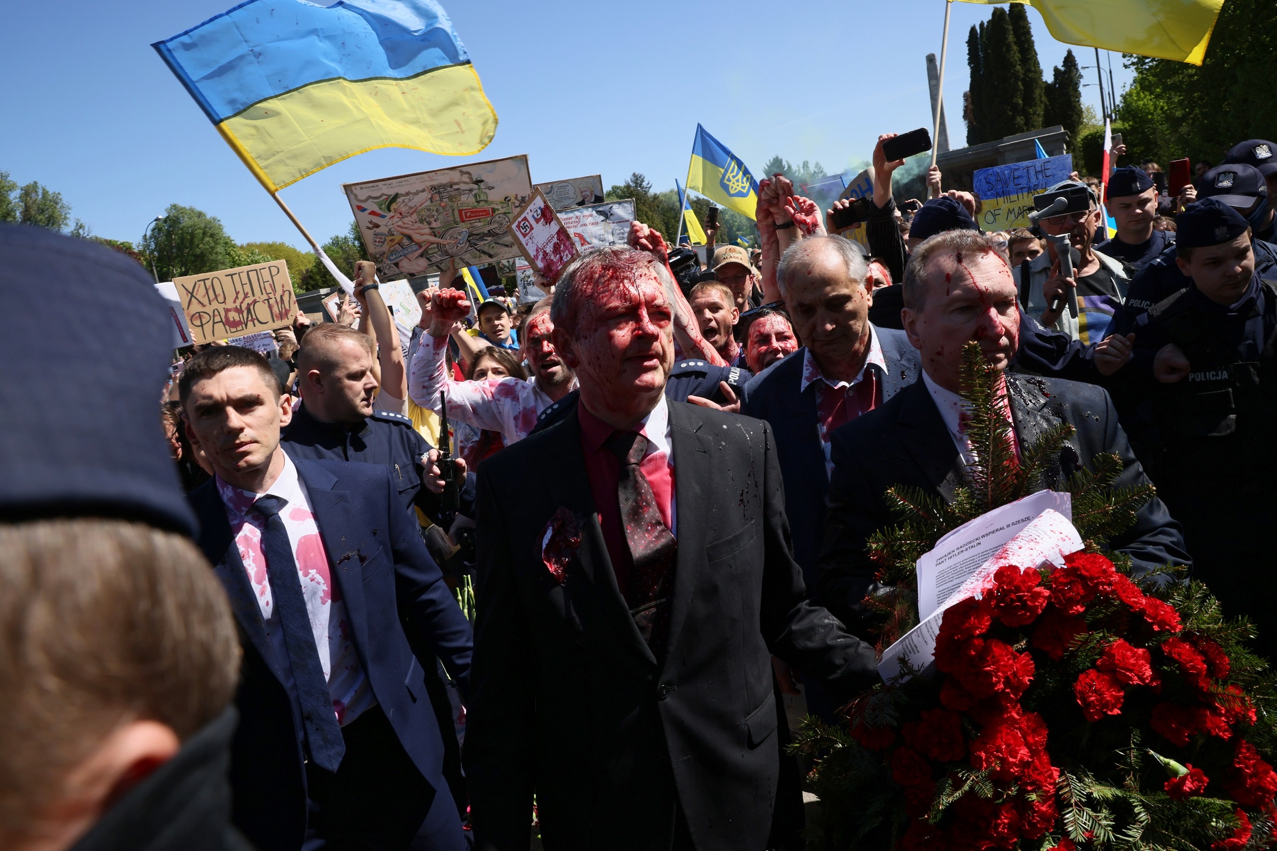 Warszawa, 09.05.2022. Ambasador Federacji Rosyjskiej w Polsce Siergiej Andiejew (C) oblany czerwoną farbą przez uczestników protestu podczas próby złożenia kwiatów przy Cmentarzu-Mauzoleum Żołnierzy Radzieckich w Warszawie.