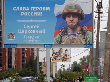 Billboard ze zdjęciem żołnierza i napisem "Chwała rosyjskim bohaterom"