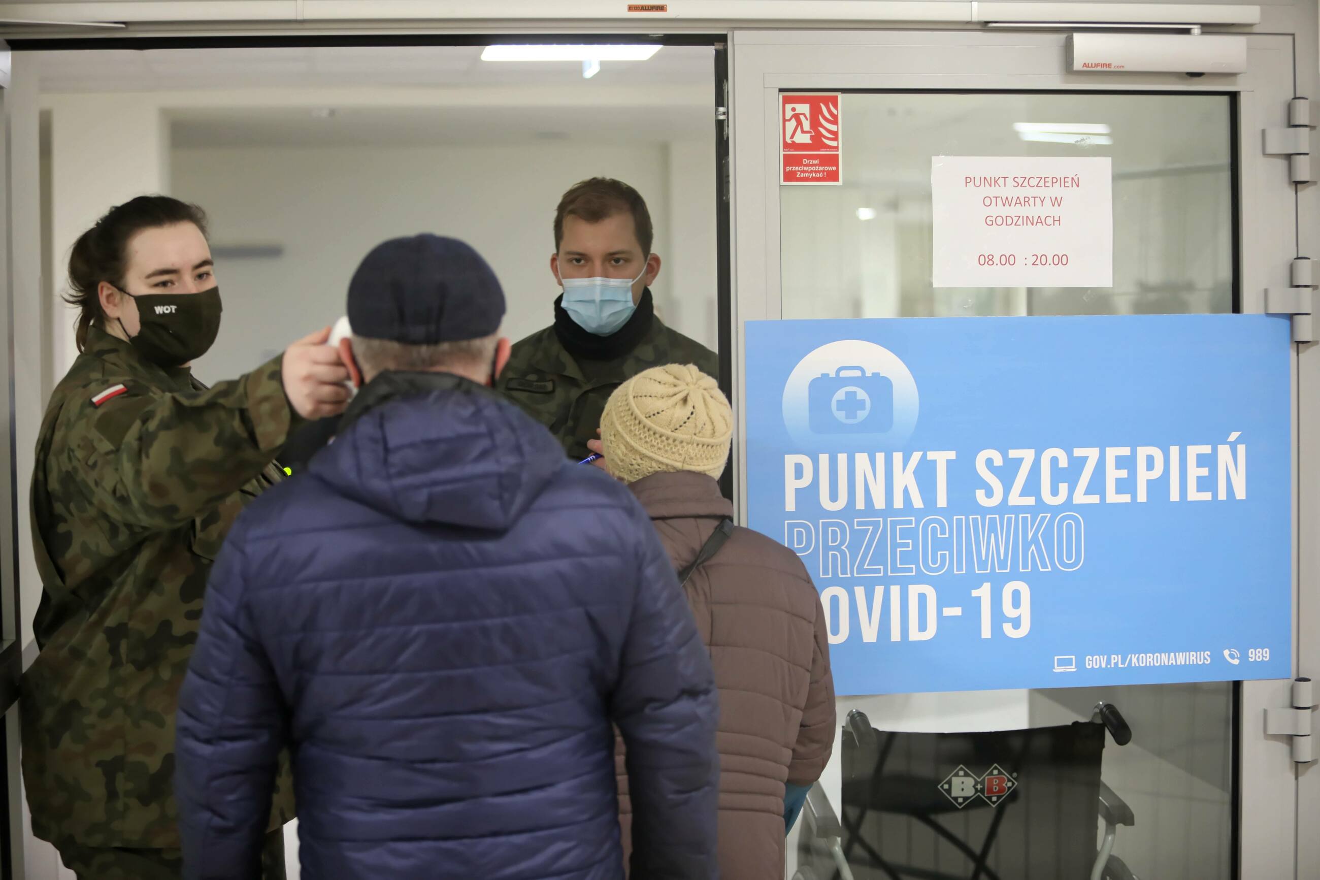 Pomiar temperatury przy wejściu do punktu szczepień w Warszawie.