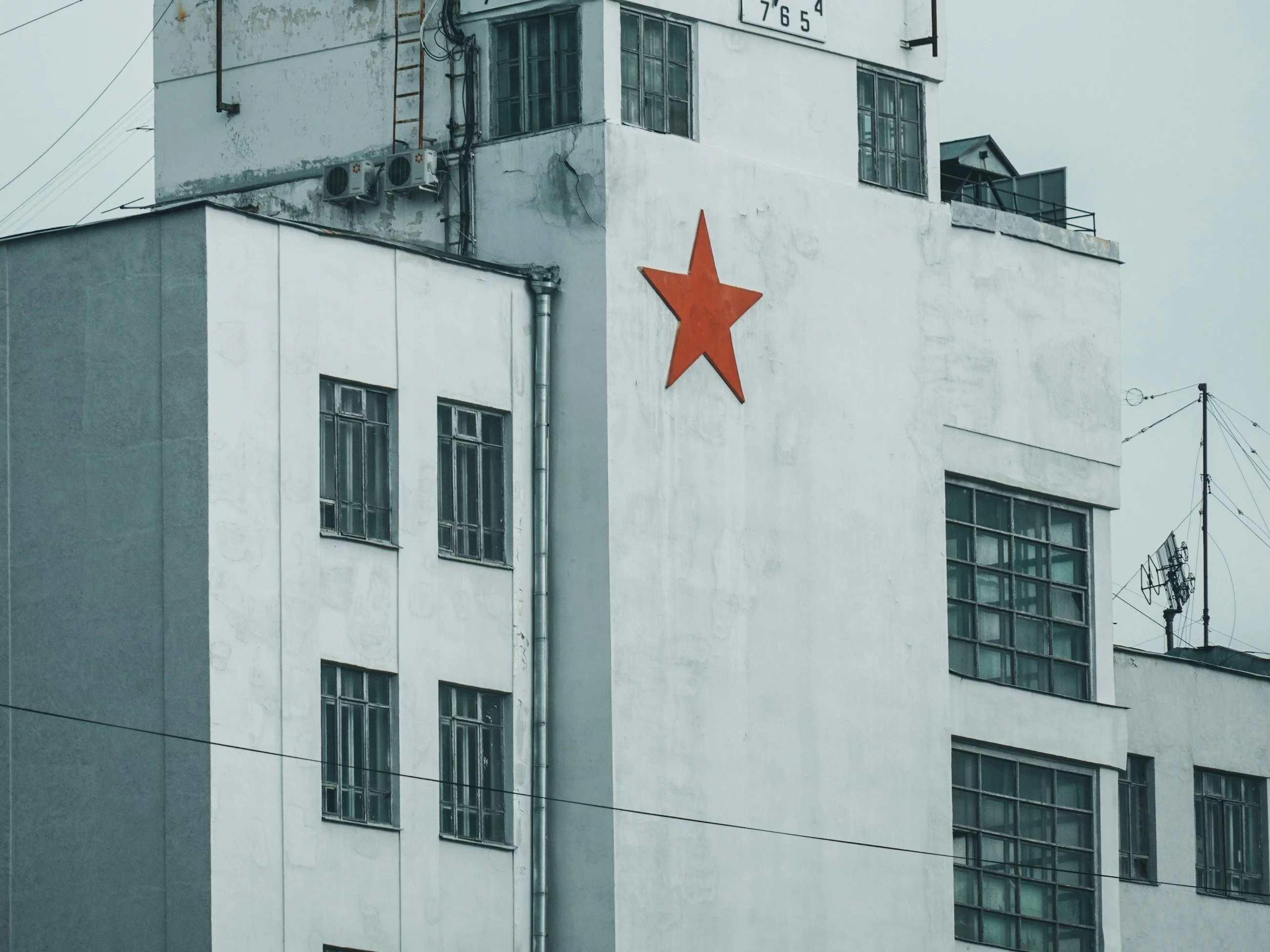 white concrete building with red star flag