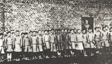 Dziewczęta na tle budynku niemieckiego obozu dla dzieci w Łodzi, około 1943 rok