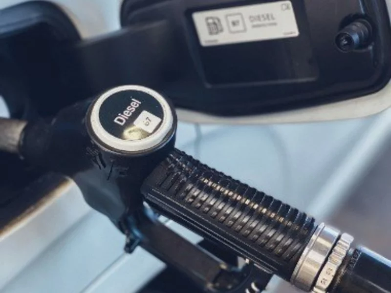 a close up of a gas pump with a car in the background