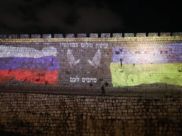 Flagi Ukrainy i Rosji narysowane na murze w Jerozolimie. Między flagami napisano fragment modlitwy w języku hebrajskim.