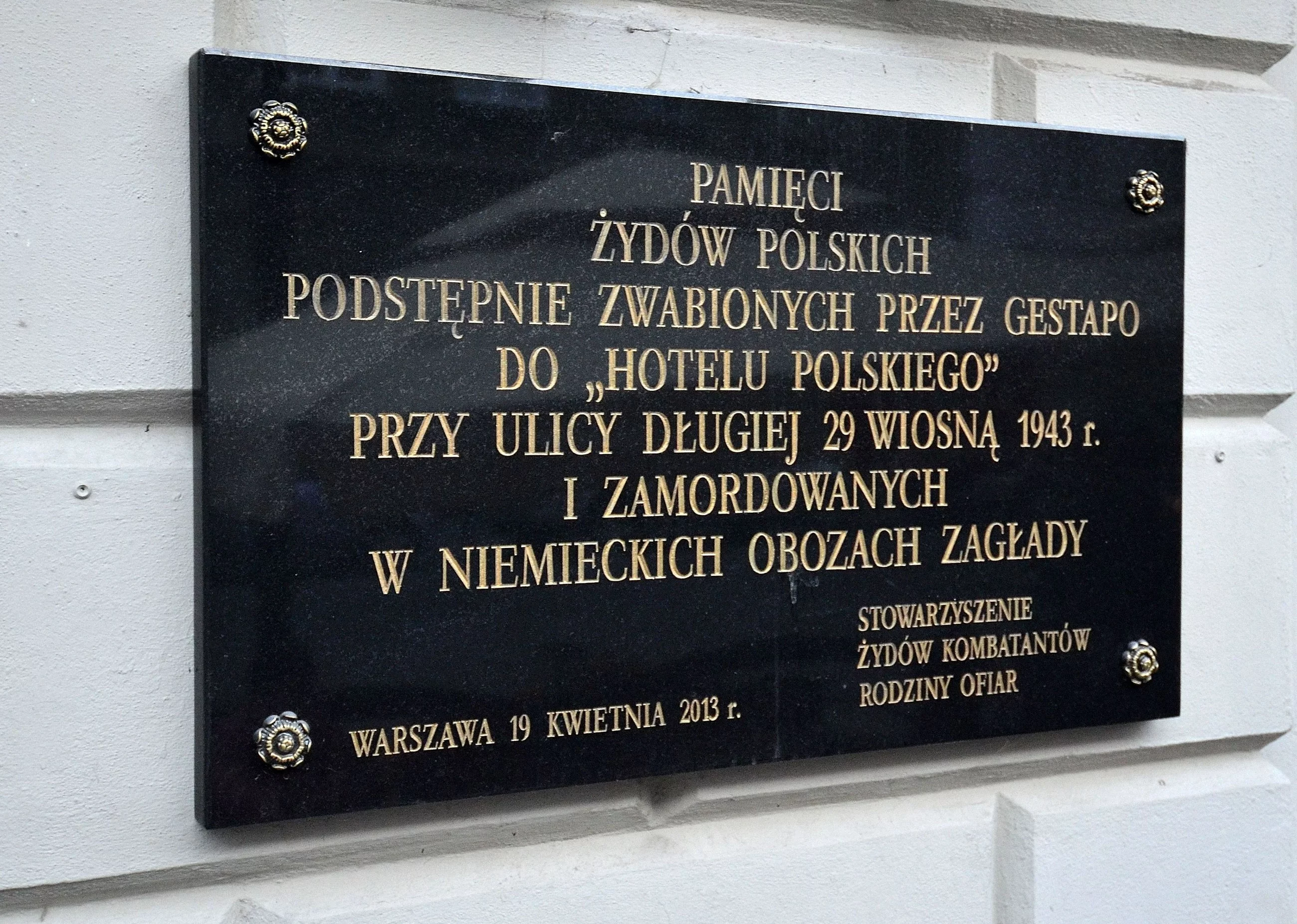 Tablica pamiątkowa na fasadzie budynku, upamiętniająca wydarzenia z 1943 roku