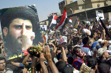 Irak, protestujący niosą portret radykalnego szyickiego duchownego Muktady as-Sadra