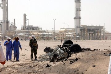 Jemeńczycy stoją przy zniszczonych samochodach