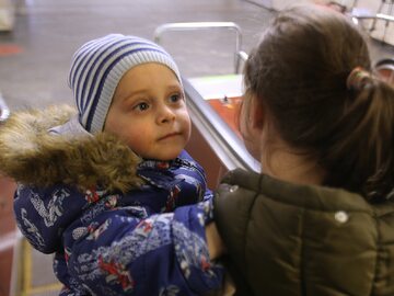 Kobieta z dzieckiem schodzi do metra w Kijowie