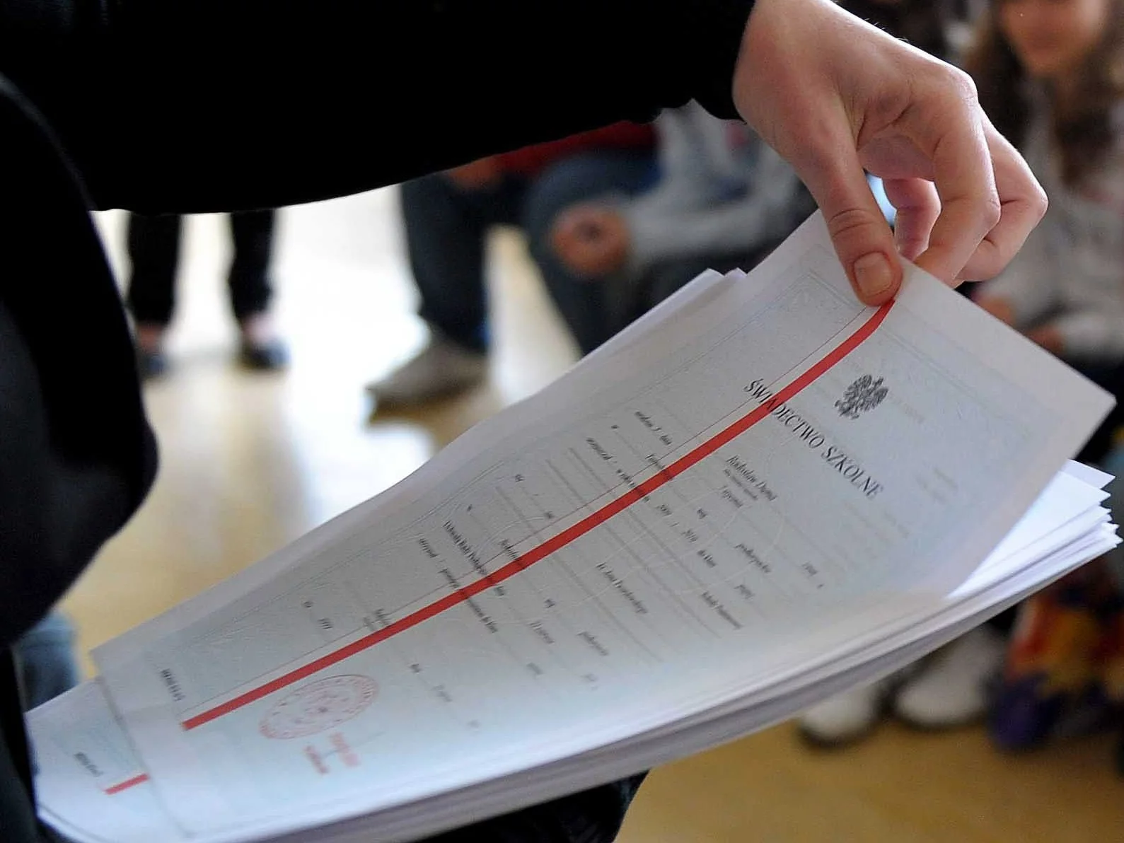 Świadectwo szkolne z biało-czerwonym paskiem, zdjęcie ilustracyjne