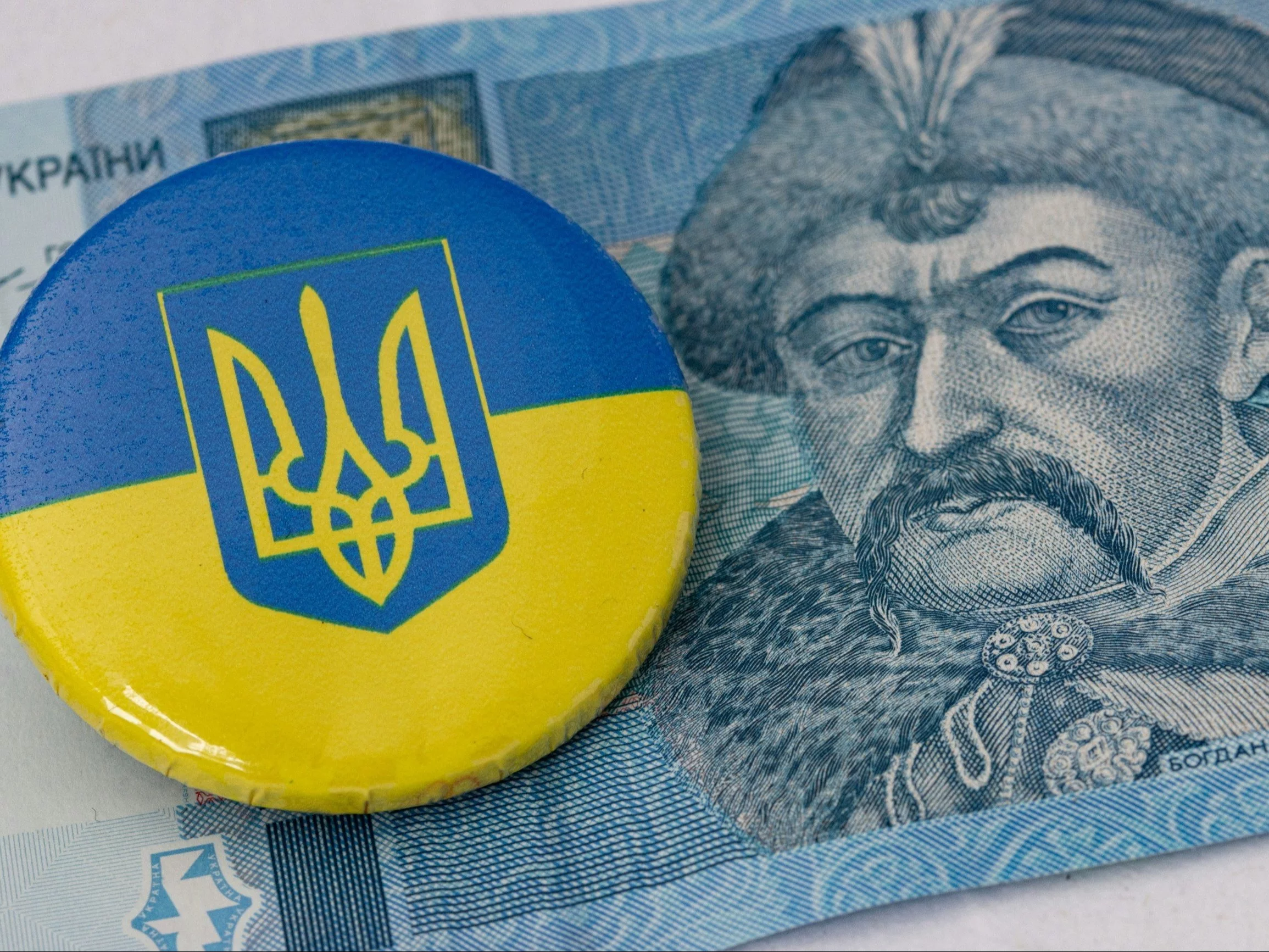 a blue and yellow button sitting on top of a money bill