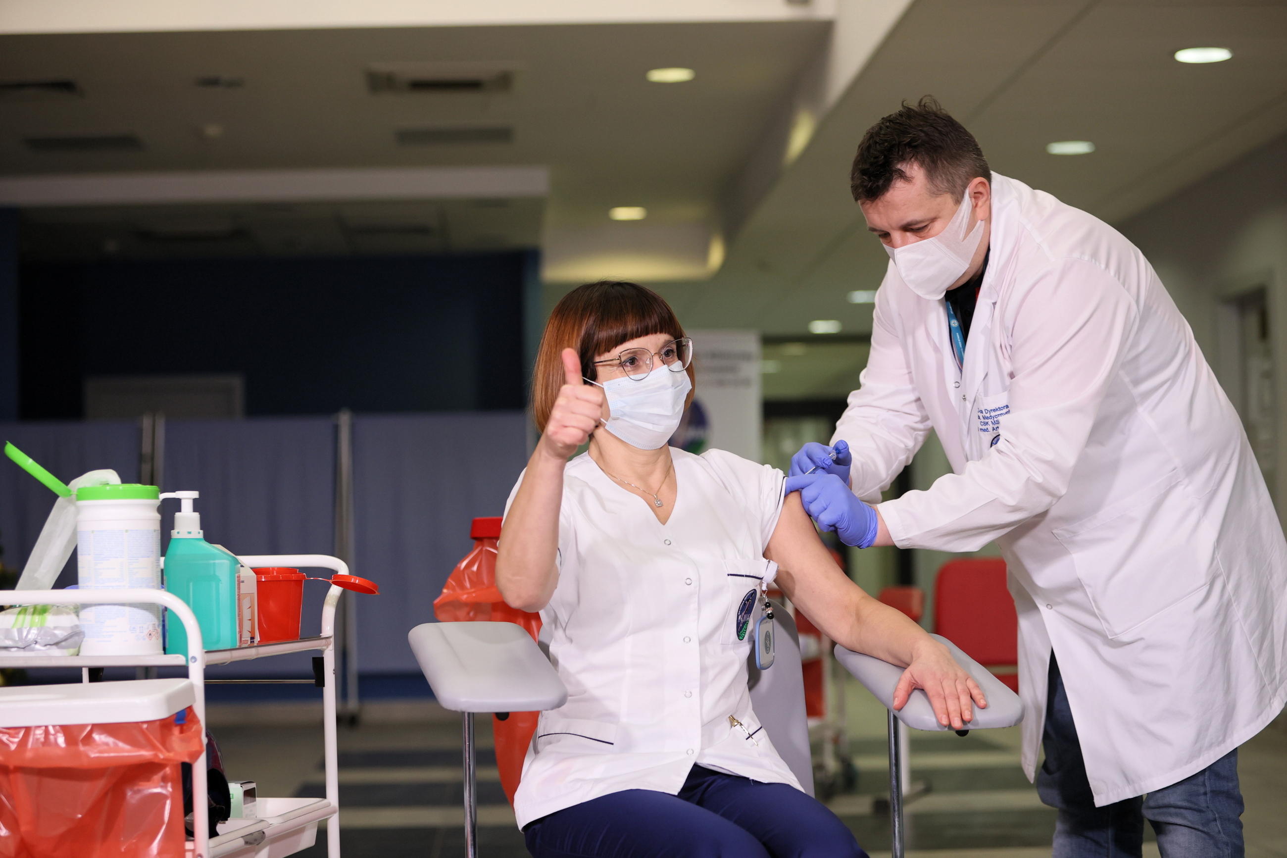 Naczelna pielęgniarka CSK MSWiA Alicja Jakubowska (L) i zastępca dyrektora ds. medycznych dr n. med. Artur Zaczyński (P) podczas szczepienia przeciw koronawirusowi COVID-19.