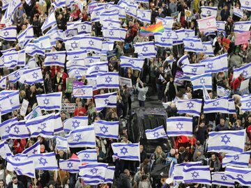 Ludzie z flagami Izraela podczas protestu w Tel Awiwie