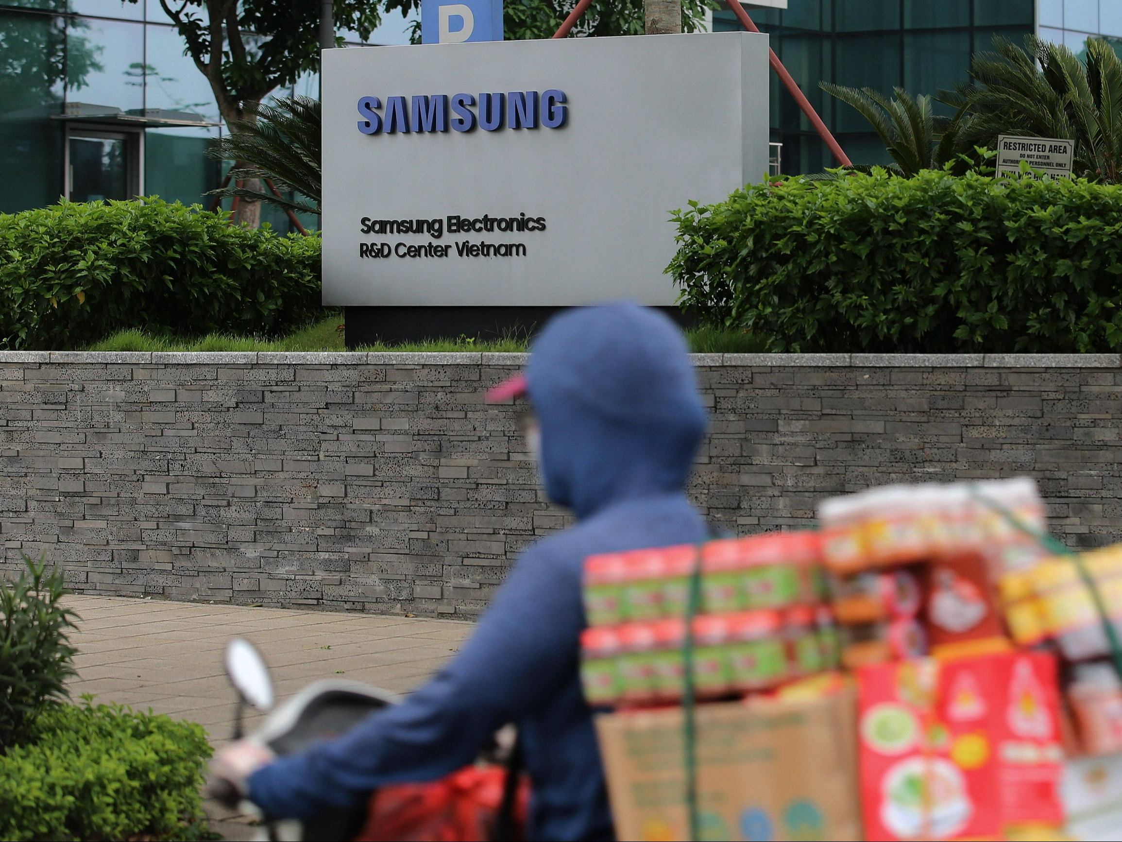 Mężczyzna przejeżdża obok centrum badawczo-rozwojowego firmy Samsung w Hanoi w Wietnamie