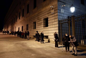 Madryt. Kolejka ludzi czekających na uzyskanie paczek z żywnością.