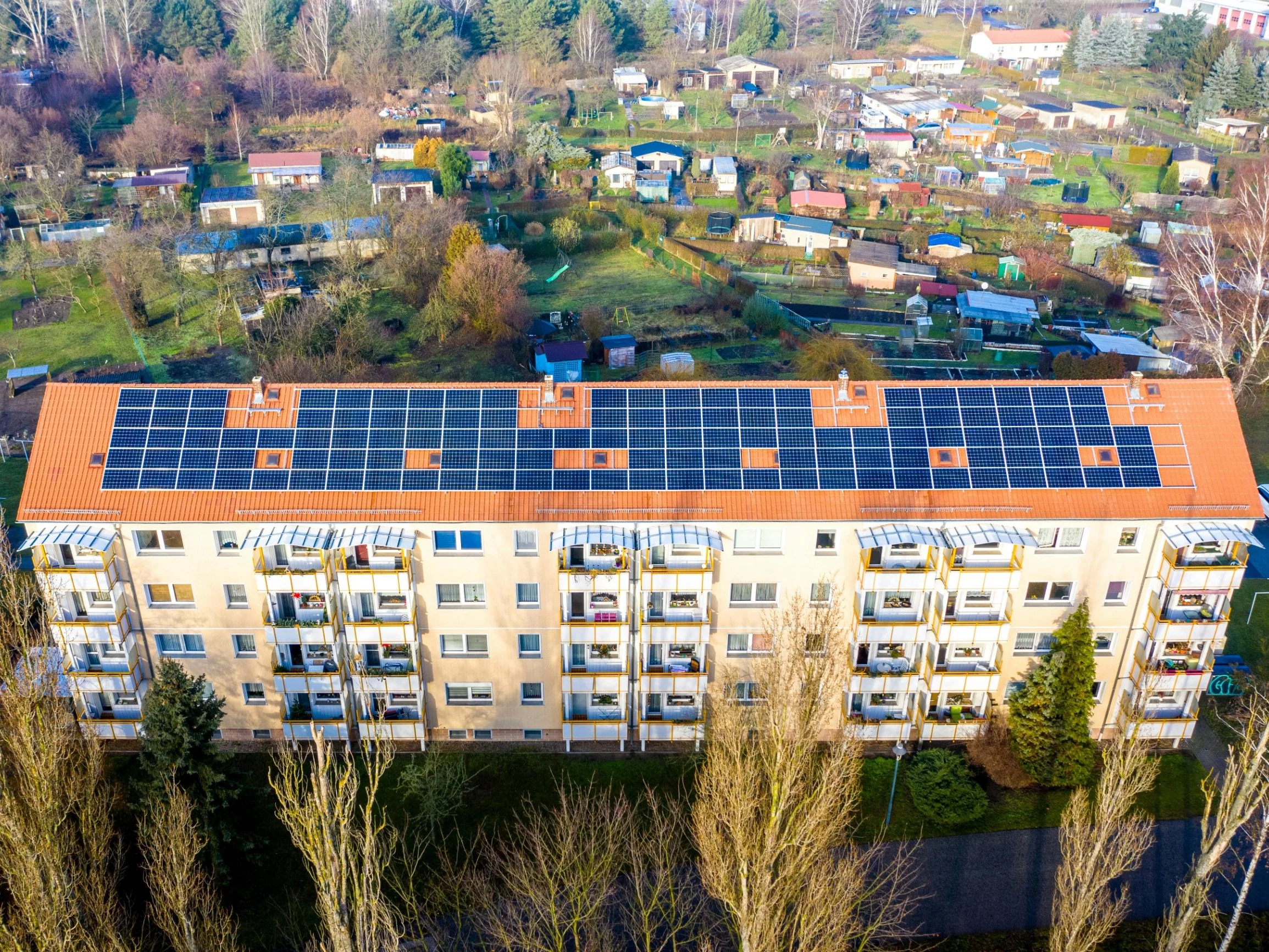 Blok mieszkalny z panelami fotowoltaicznymi na dachu