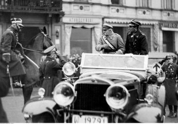 Marszałek Józef Piłsudski w towarzystwie Józefa Becka przyjmuje raport od wiceministra spraw wojskowych gen. Daniela Konarzewskiego (na koniu)