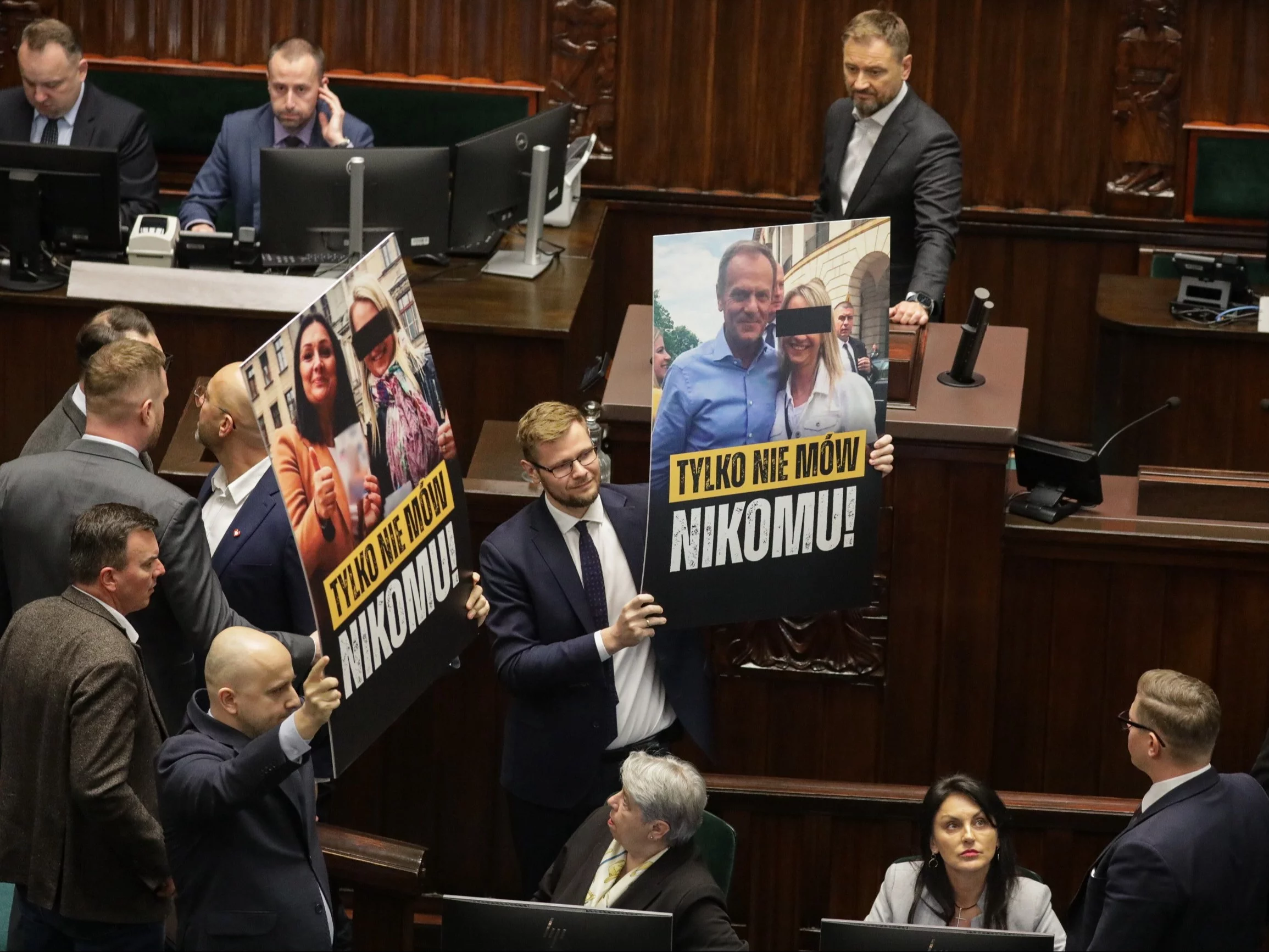 Posłowie prezentują baner na sali plenarnej Sejmu