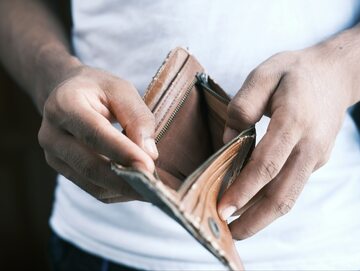 Mężczyzna trzymający w ręku pusty portfel